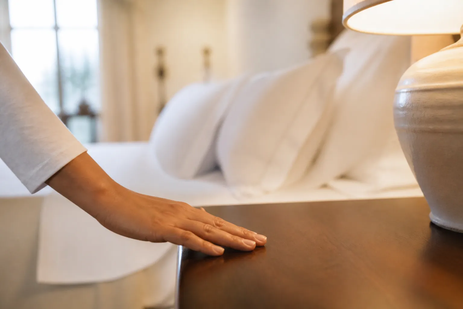 Ospite osserva con attenzione i dettagli di una camera hotel appena pulita